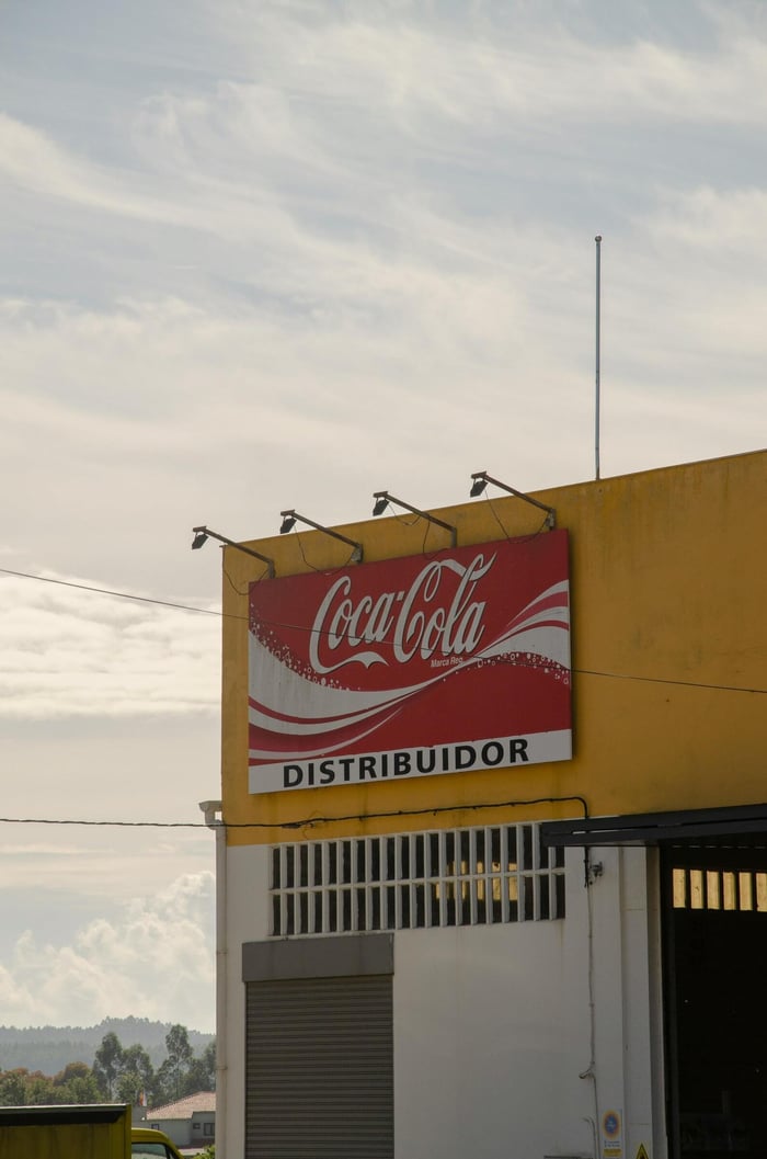 Outdoor view of Coca-Cola distributor sign on a building under a clear sky.