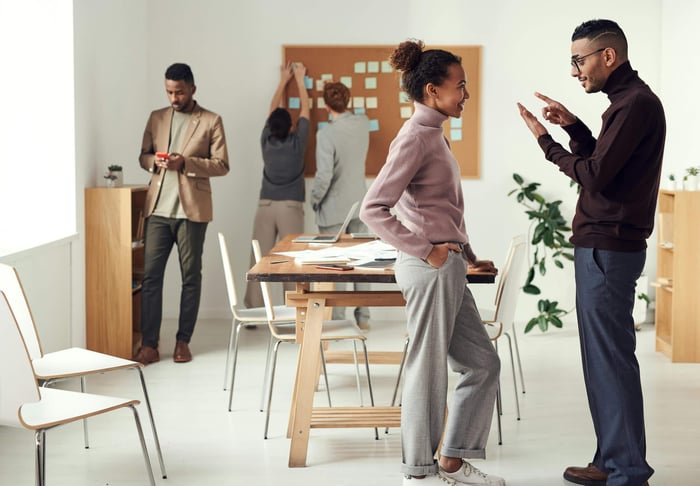 Colleagues engaging in teamwork and brainstorming in a modern office space.
