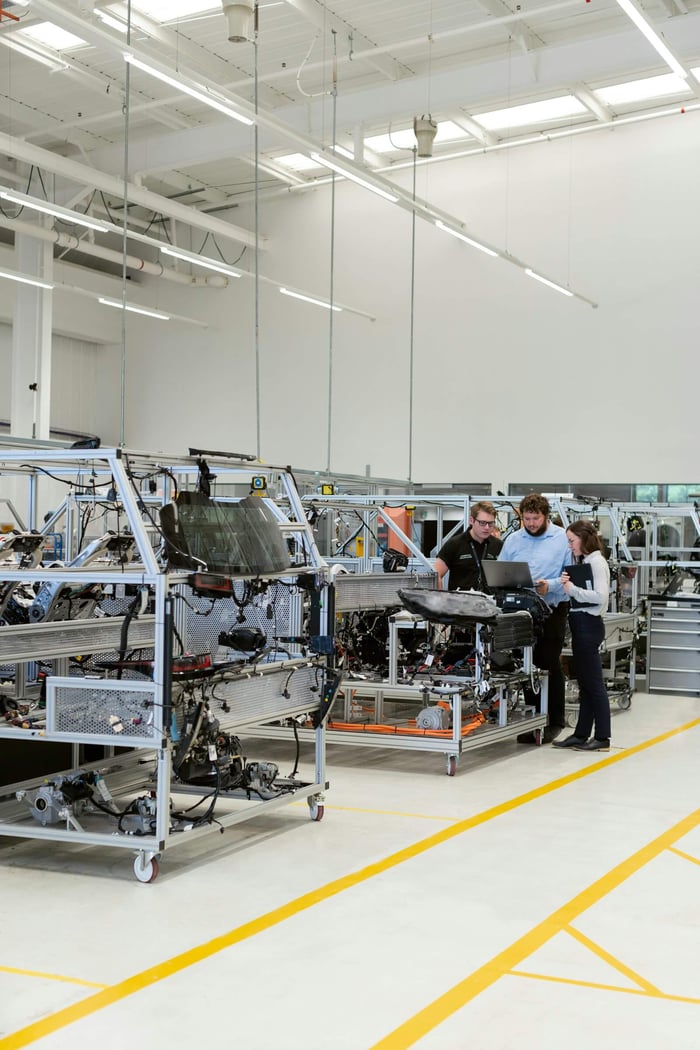 Team of engineers discussing projects in a high-tech factory setting.