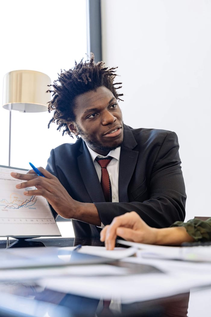 Business professional explaining charts in a modern office setting.