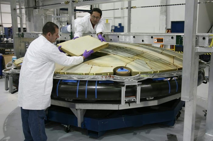 Aerospace engineer reviewing technical content on a tablet about advanced manufacturing capabilities and certifications