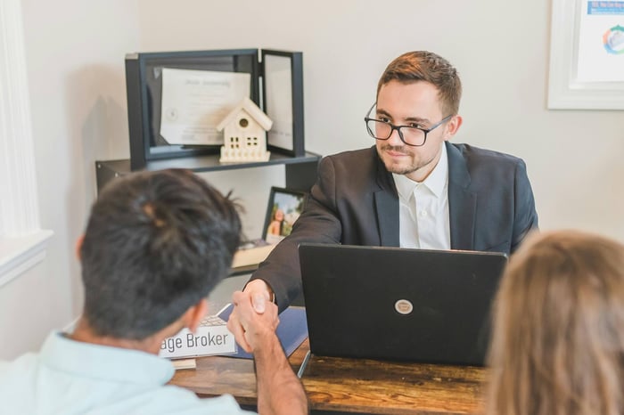 private equity professionals analyzing increasing broker fees on a financial projection chart
