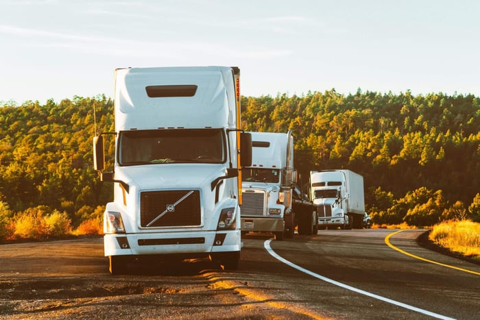 Convoy of trucks parked along the side of the road.