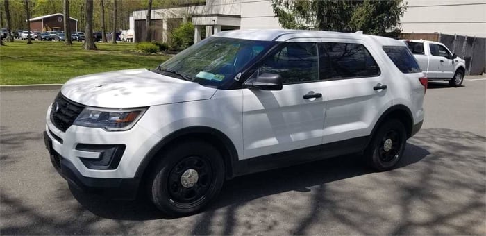 A white Ford Explorer sitting on a driveway.
