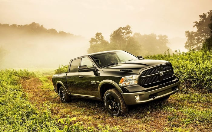 Black Ram 1500 truck, praised for its performance, with adaptive cruise control and crew cab driving though a field.