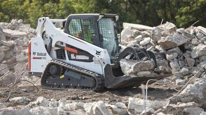 White skid steer loader with modfied wheels which are good for landscaping.