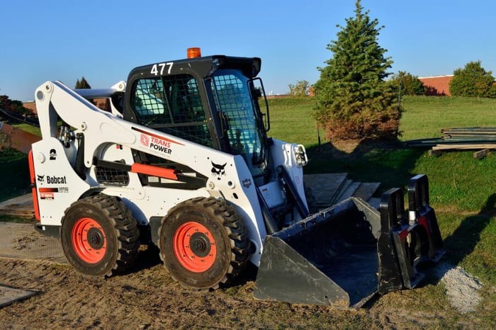 Skid steer loader in a field.