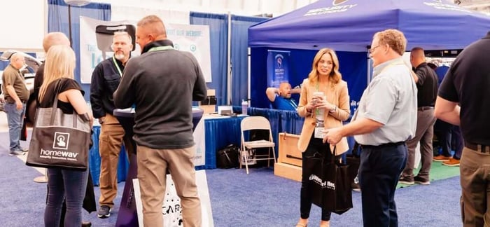 Exhibitors speaking with attendees at the NSA.