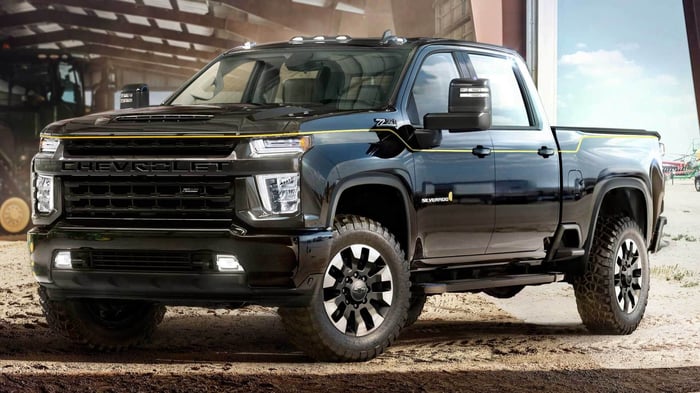 Black Chevrolet Silverado parked on dirt in a hangar, suitable for winter driving.