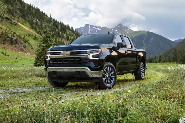 Dark blue Chevy Silverado parked in a field, with 12.2–12.9 liters per 100 kilometers fuel economy, Android Auto, crew cab, and spacious front seats.