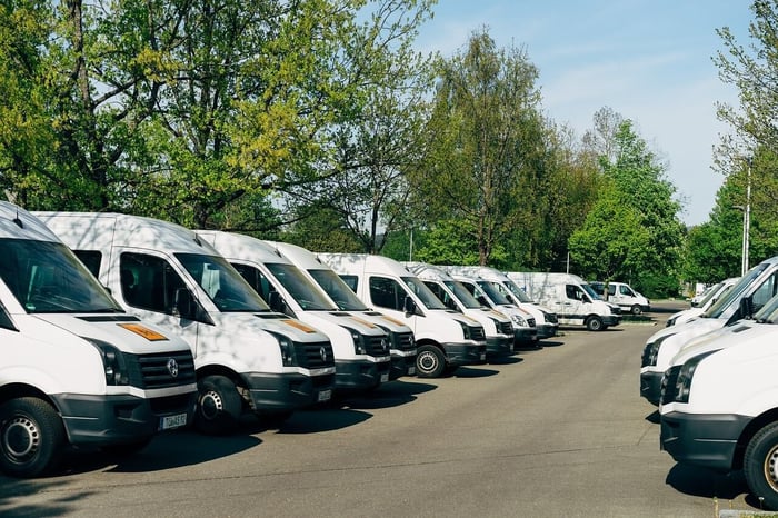 Fleet of white vans, used for deliveries.