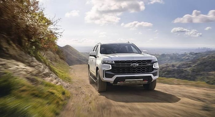 White Chevy Tahoe with third row seats, rear parking sensors, auto dimming rearview mirror, and head up display.