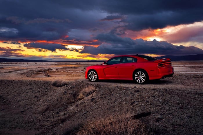 Red 2011 model year Dodge Charger on a road.