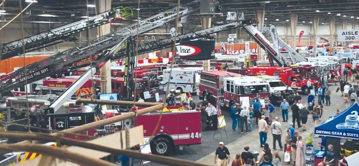 The exhibition hall at Fire Expo showcasing many different fire trucks.