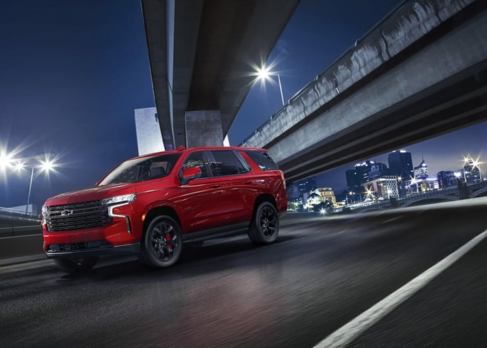 Red Chevy Tahoe with third row seats and adaptive air suspension, ventilated front seats, and head up display.
