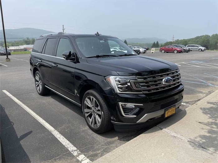 A photo of a Ford Expedition SUV; this SUV is black and sitting in a parking lot.