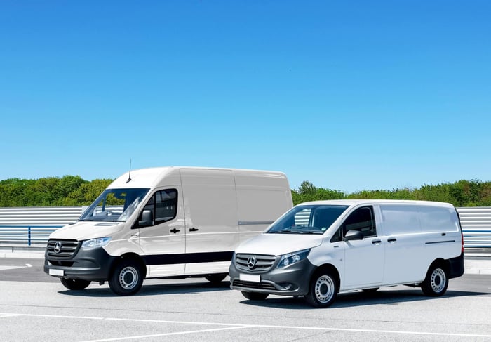 Two delivery vehicles parked on pavement.