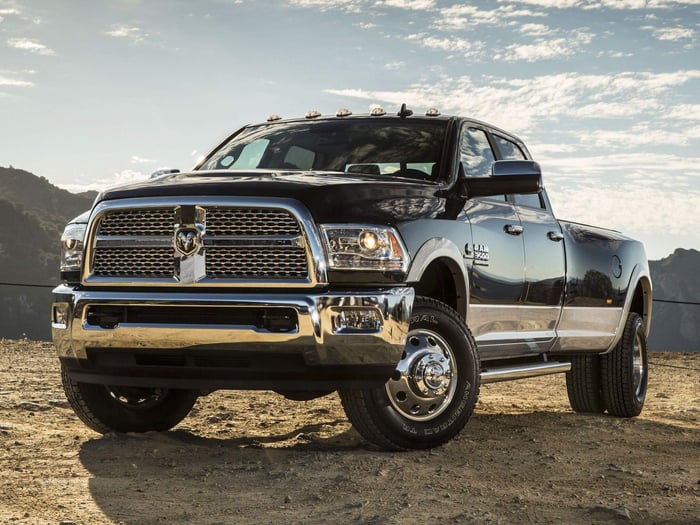Black Ram truck with crew cab and comfortable front seats parked on a dirt road.