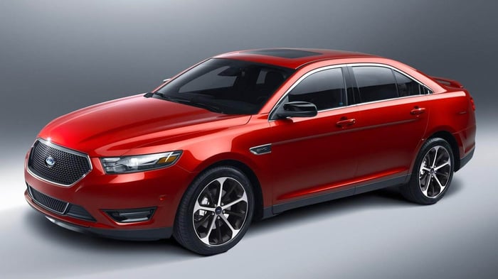 Red Ford Taurus car with center console and good reliability among drivers.