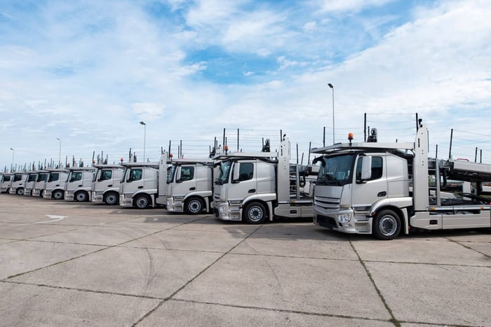 Group of transport trucks parked side by side.