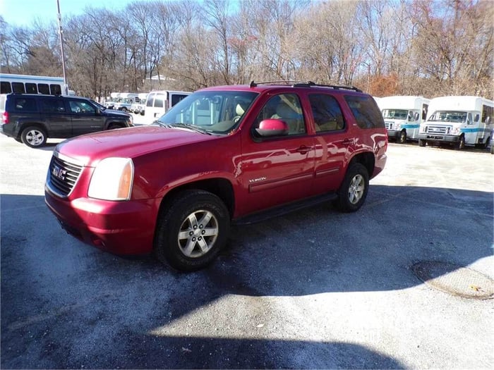 A red GMC SUV in a parking lot covered in rock salt.