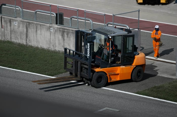 Orange forklift truck, a good example of material handling equipment that is useful on construction sites, others include wheel loaders, reach trucks, tow tractors, cat equipment, cat lift trucks, and truck mounted forklifts.