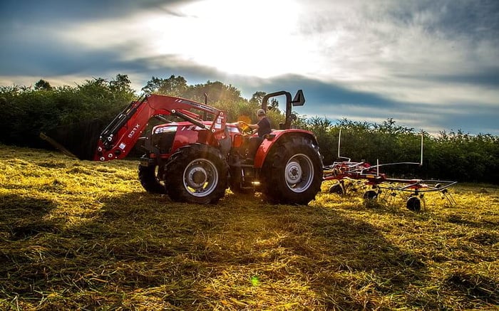 MF 4708 model picking grass for hay and forage in a field.