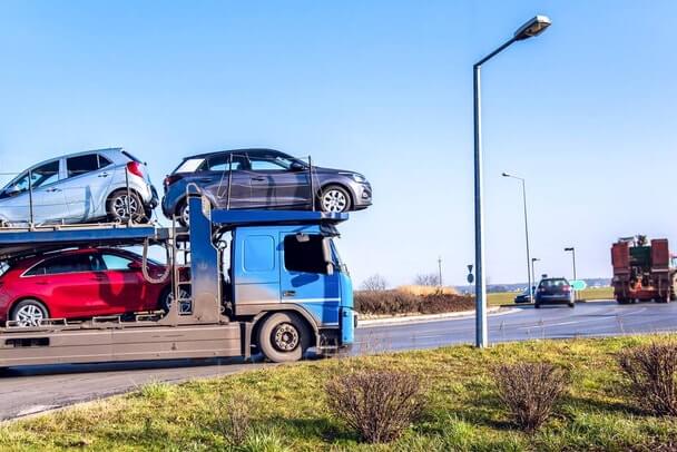 Vehicles getting shipped on the highway betweeen states.
