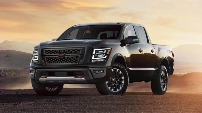 Black 2022 Nissan Titan parked on dirt at sunset.