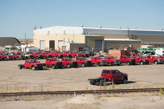 Parking lot full of red trucks used by a company.
