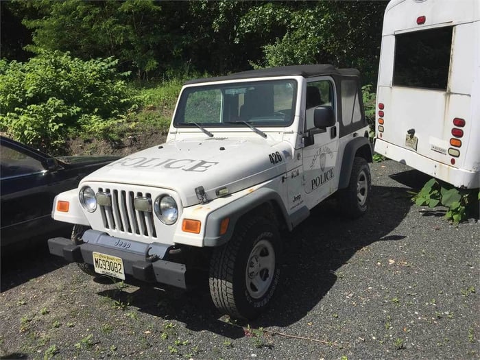 An image of a white Jeep Wrangler, which happens to be a retired police vehicle.