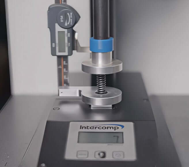 Federwaage, die eine Feder prüft