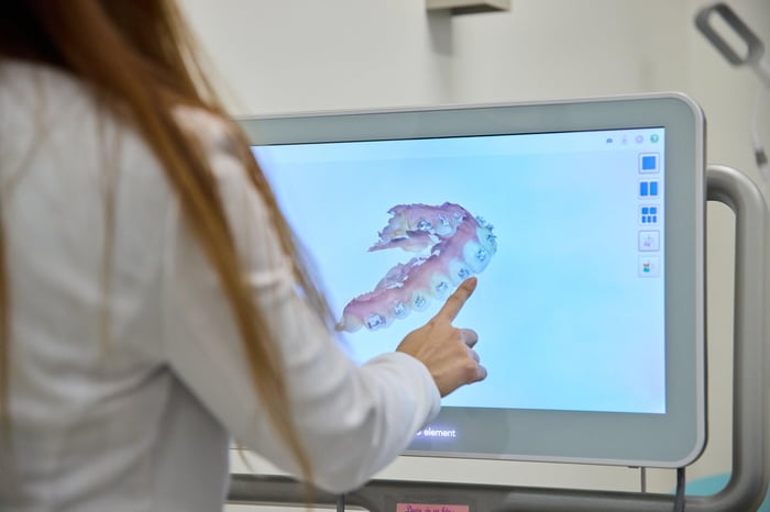 A woman pointing to a monitor