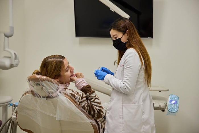 A woman talking to a patient sitting on a dental chair