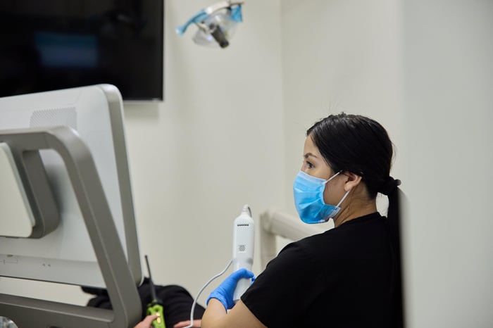 A woman wearing a face mask talking to a person
