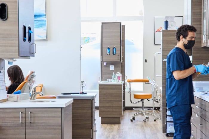 A person wearing a blue scrub standing