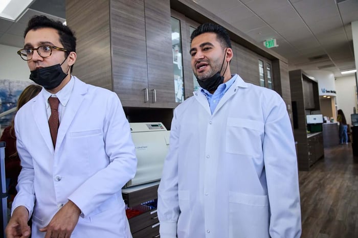 Two person wearing a black face mask