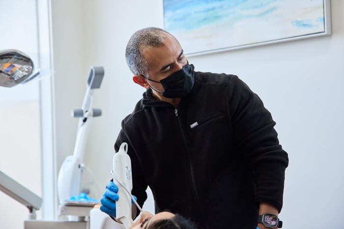 A person wearing a black jacket and black face mask