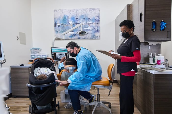 A dentist and an assistant working on a patient