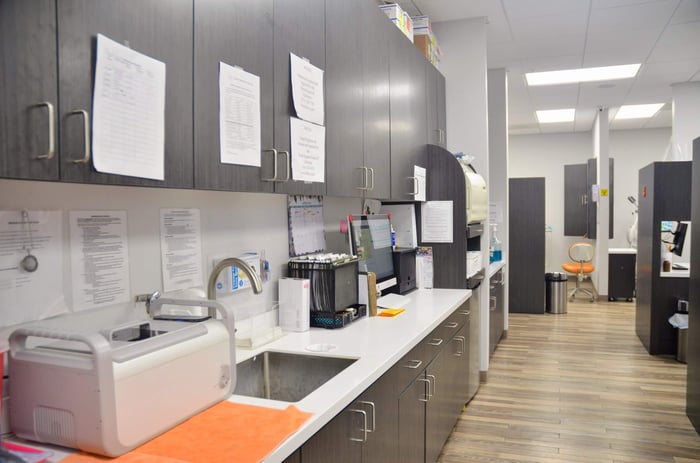 A room with a faucet and black cabinets