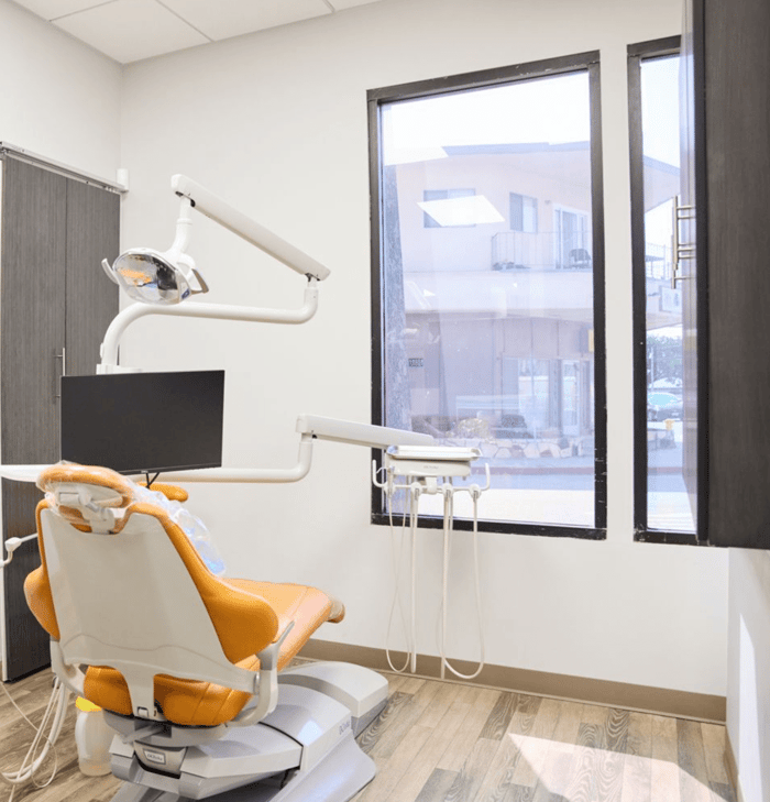 A dental chair in front of a monitor