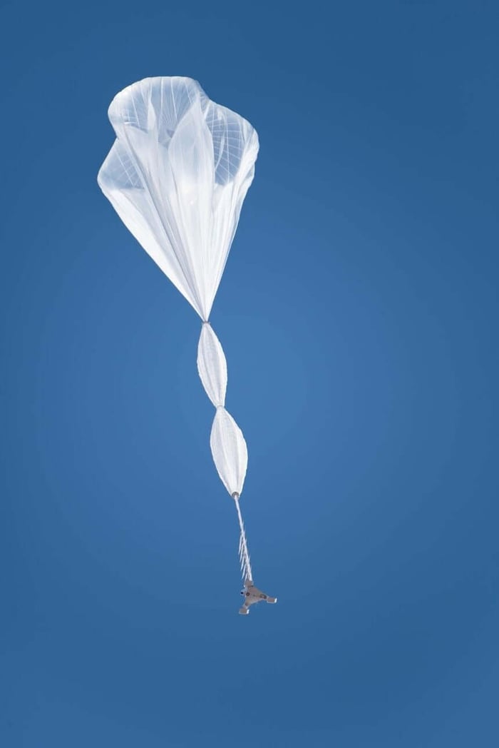 A large white translucent balloon floats to the sky