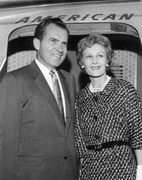 Portrait of former American Vice President Richard Nixon and his wife, Pat, smiling together in the entrance of an American Airlines jet before their...