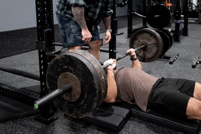 athlete performing floor press for jiu jitsu training