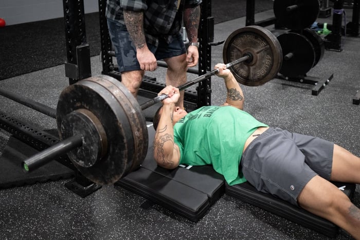 athlete performing floor press for jiu jitsu training