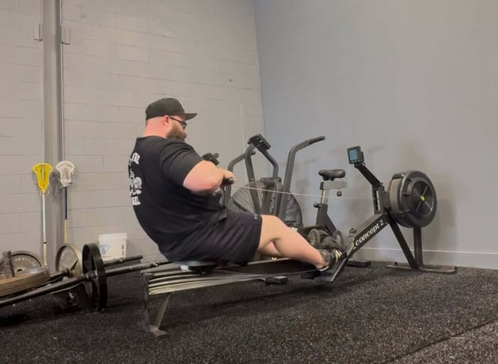 Athlete performing row workout with row machine.