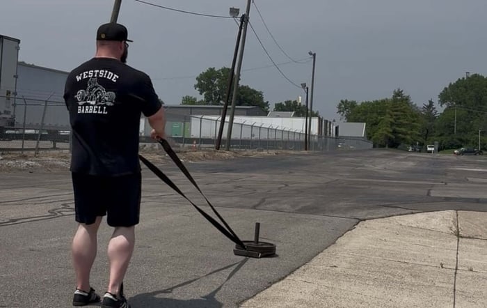 Athlete performing backward sled pull.