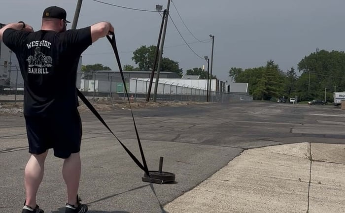 Athlete performing face pulls with sled.