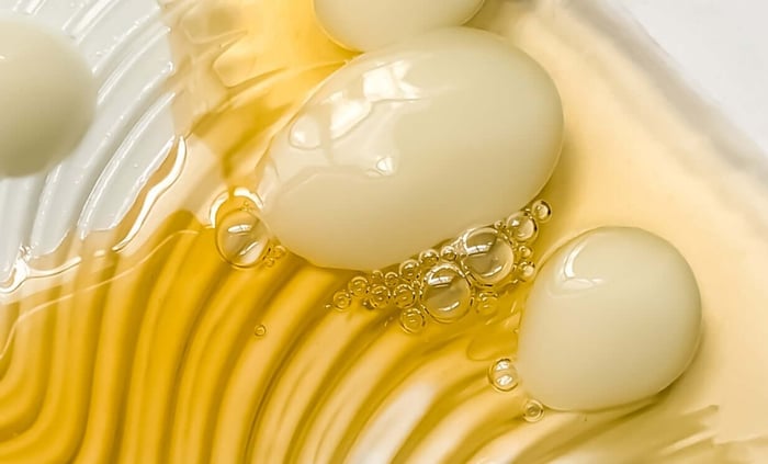 Golden skincare oil with bubbles and smooth texture showing ceramide-rich formula for sensitive skin