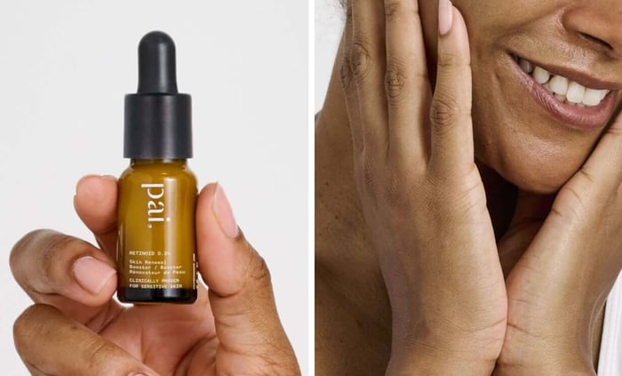 Hands holding Pai Retinoid 0.3% serum bottle with golden oil and black dropper against white background
